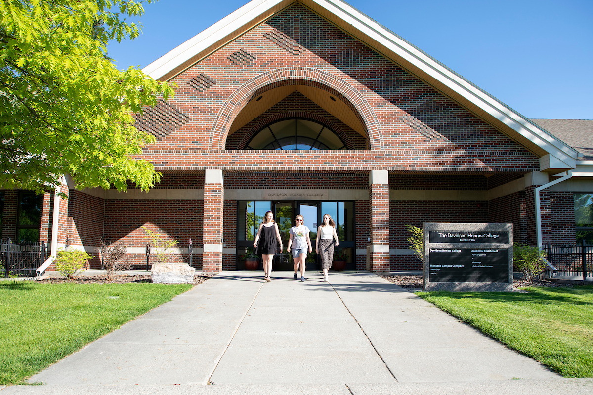3 students walking out of DHC building