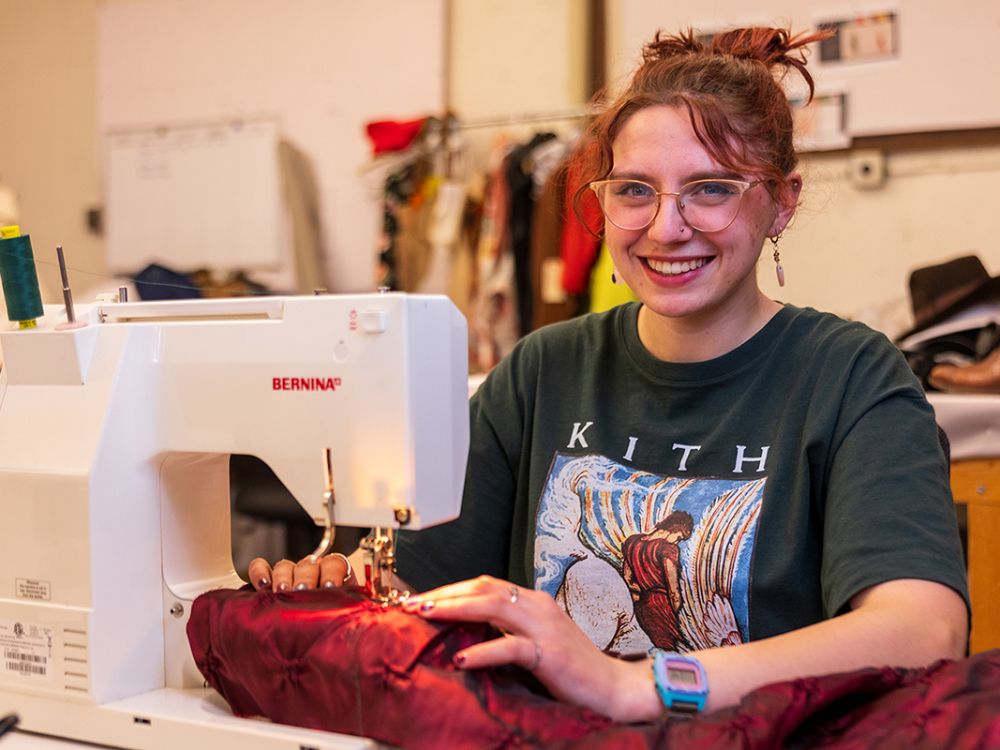 Senior Ronnie Avansino works with a sewing machine in a backstage area at the University of Montana. (UM photo by Noah Epps)