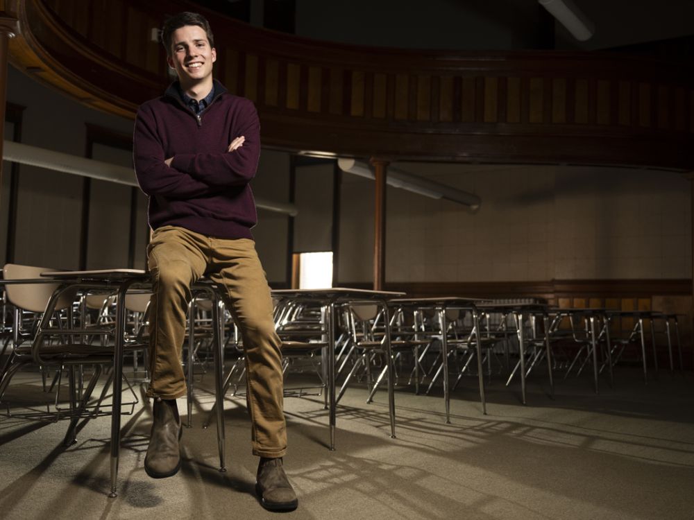 Buddy Wilson facing camera, leaning on desk