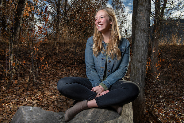Student sitting on a rock.
