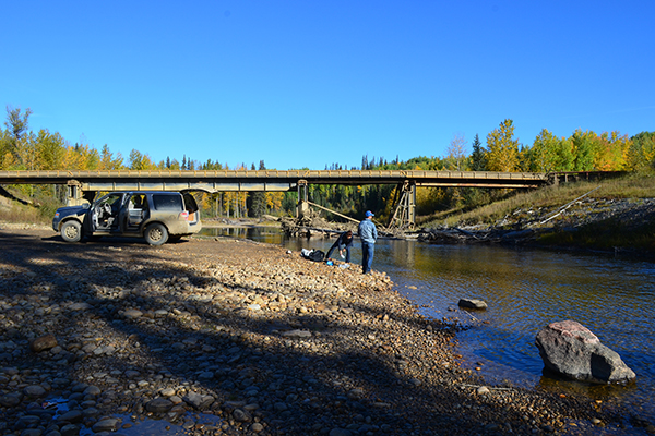 vehicle and paeople on river bank