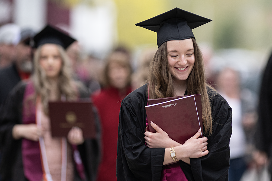 A student holds a graduation dipolma at Commencement 