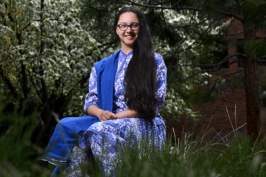 A picture of a woman sitting in campus flower garden 