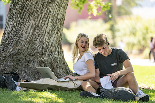 A picture of two students sitting in the sun 