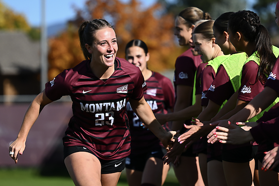 A female soccer player celebrates with her team