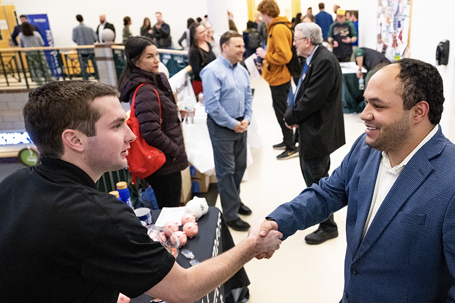 A UM student shakes the hand of a potential employer at the UM Jobs Fest 