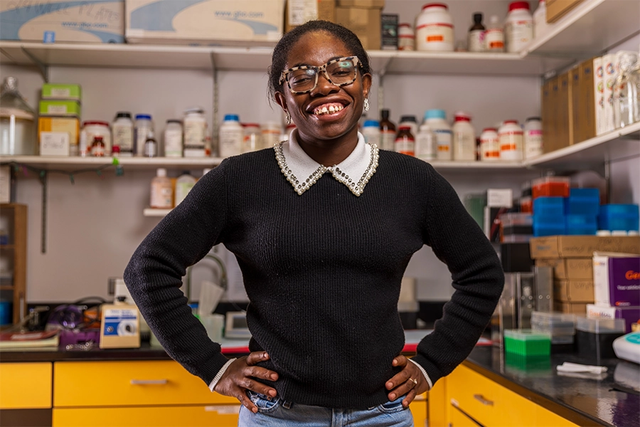 A picture of grad student standing in front of a medical lab