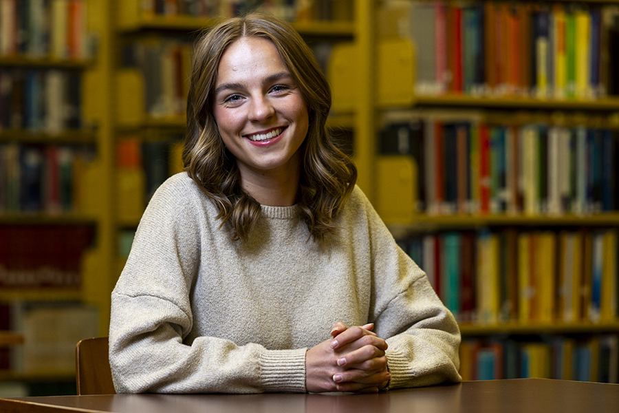 A picture of a woman sitting at a desk in the library 