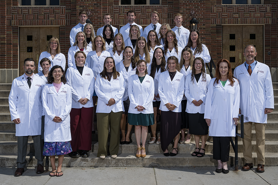 Students in UM's physician associate program gather in white coats 