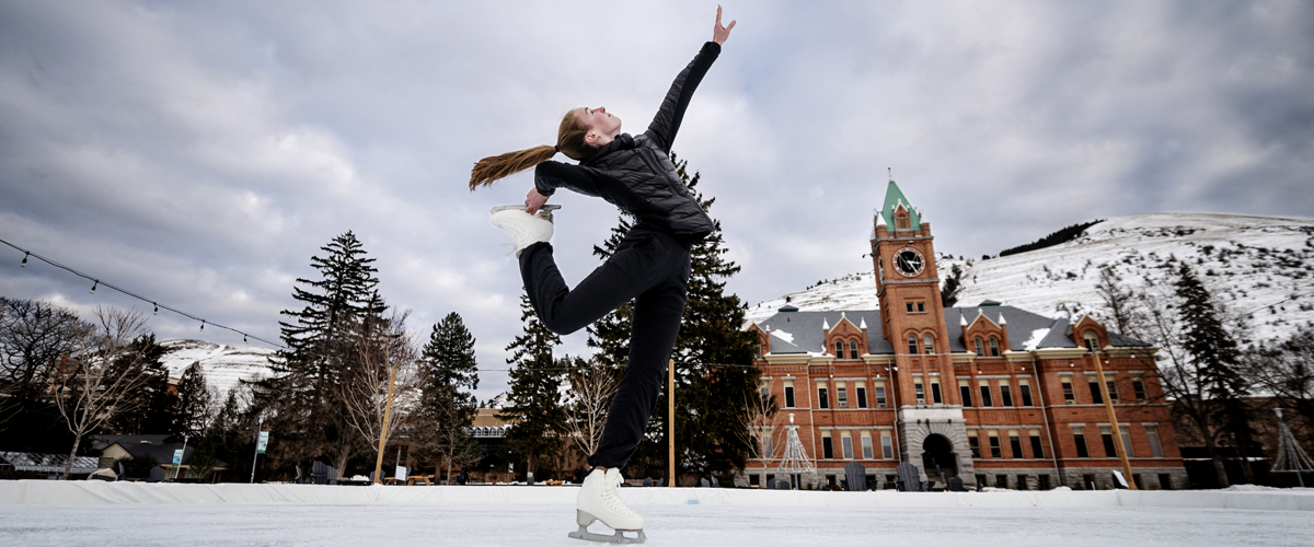 A student skates across the ice rink on the UM Oval in front of Main Hall. 