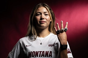 A female soccer player shows her championship rings 