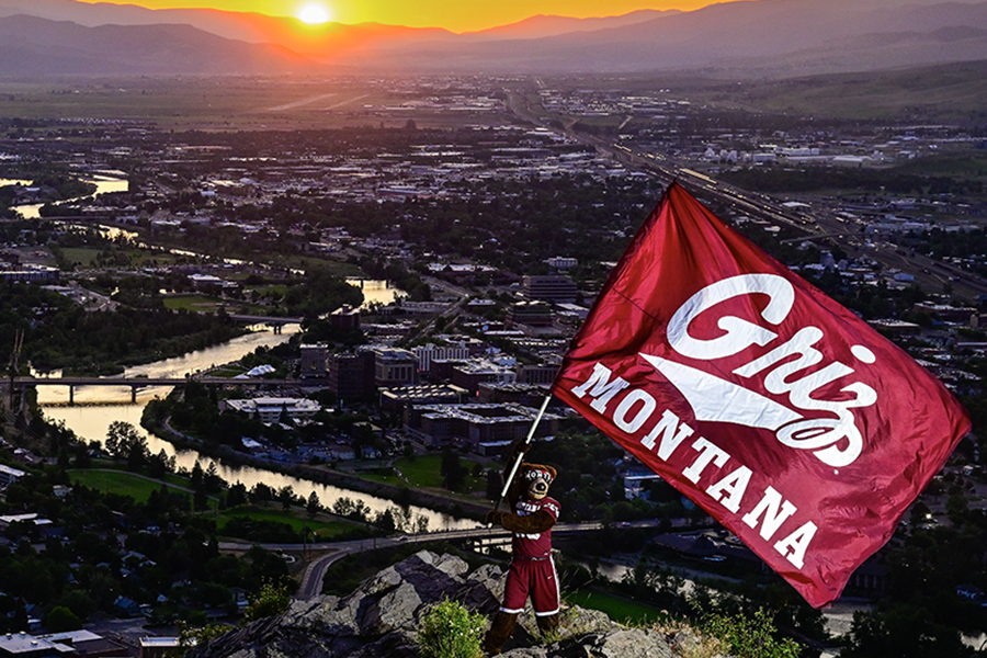 A picture of Monte waving a Griz flag above Missoula.