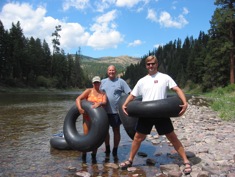 3 people posing with inner tubes by th eriver
