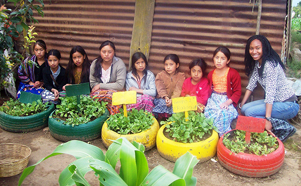 peace corps volunteer with girls at a farm