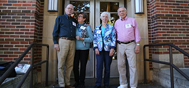 Former J-School grads pose in front of the Old Journalism School Building.