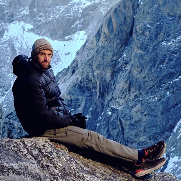 Man sits on top of mountain