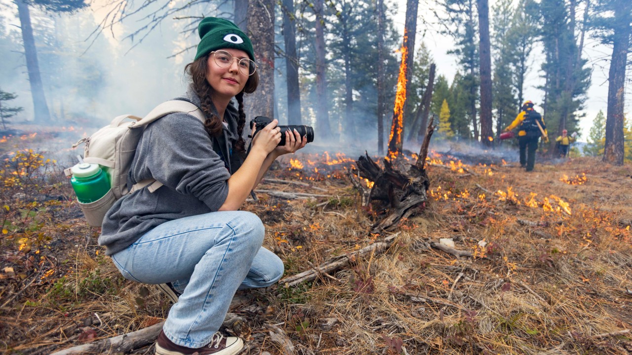 Rachel Yeager shoots a prescribed burn at the Lubrecht Experimental Forest as part of this year's Byline class. Photo by Marley Barbo-Eisel