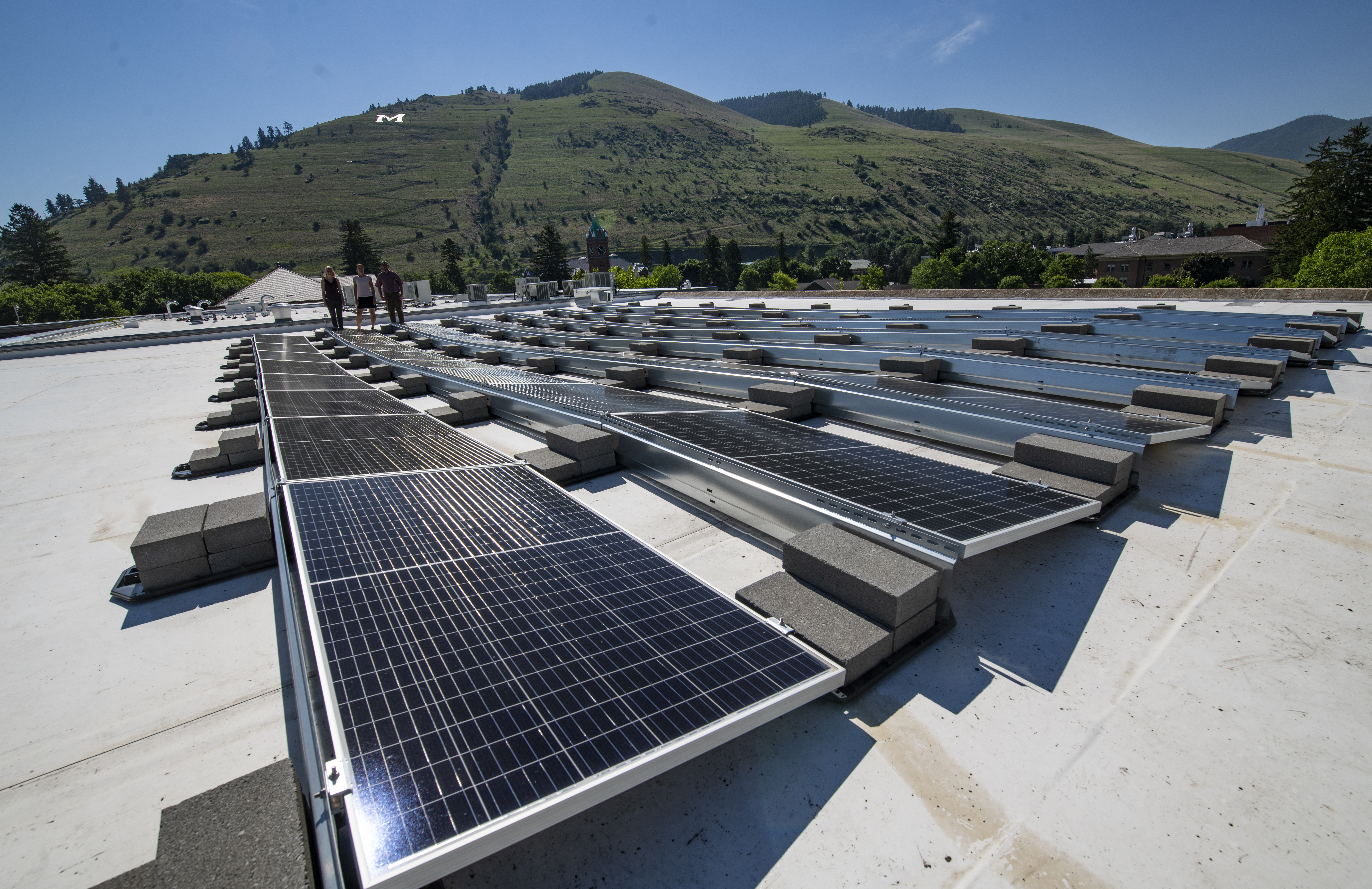 solar arrays on top of a building shining in the sun