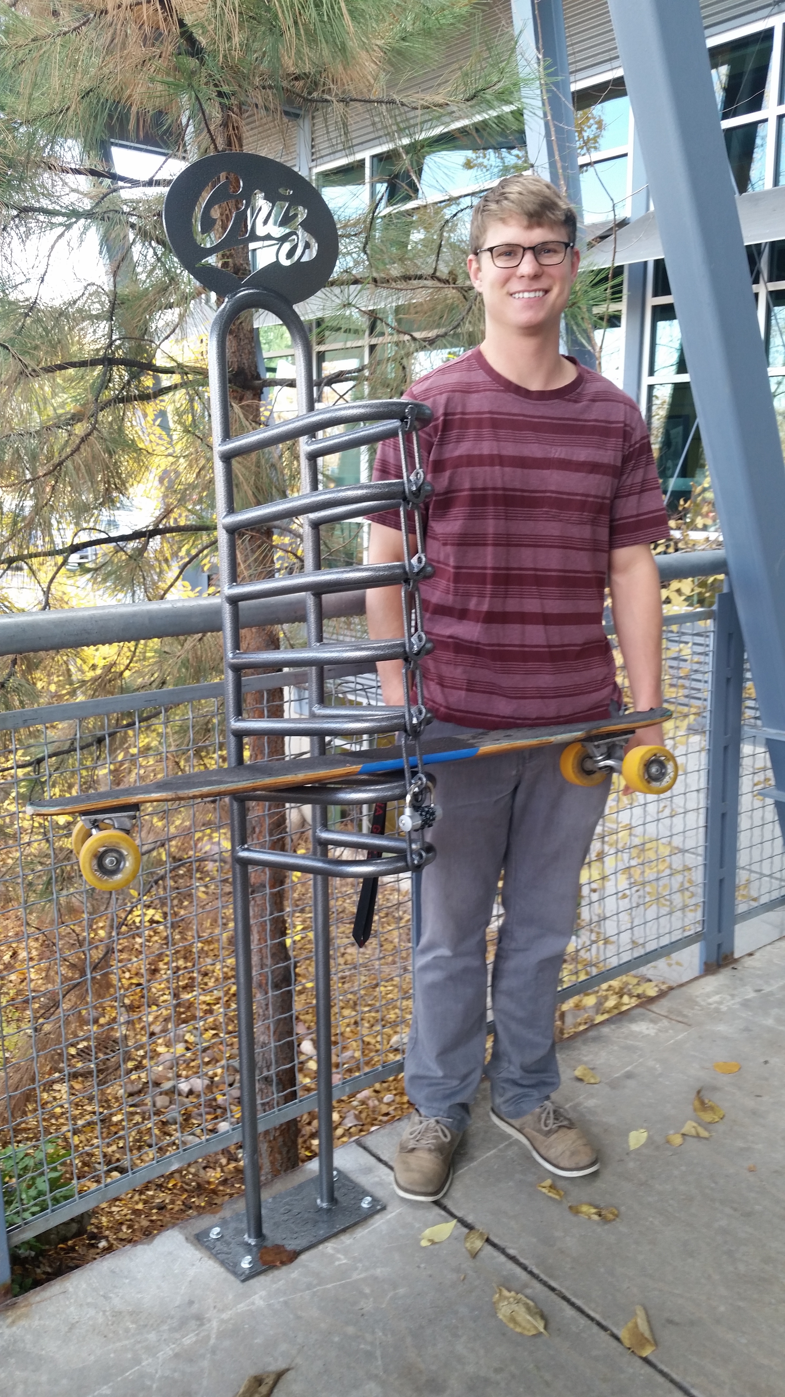 students stands next to longboard racks at the Campus Recreation