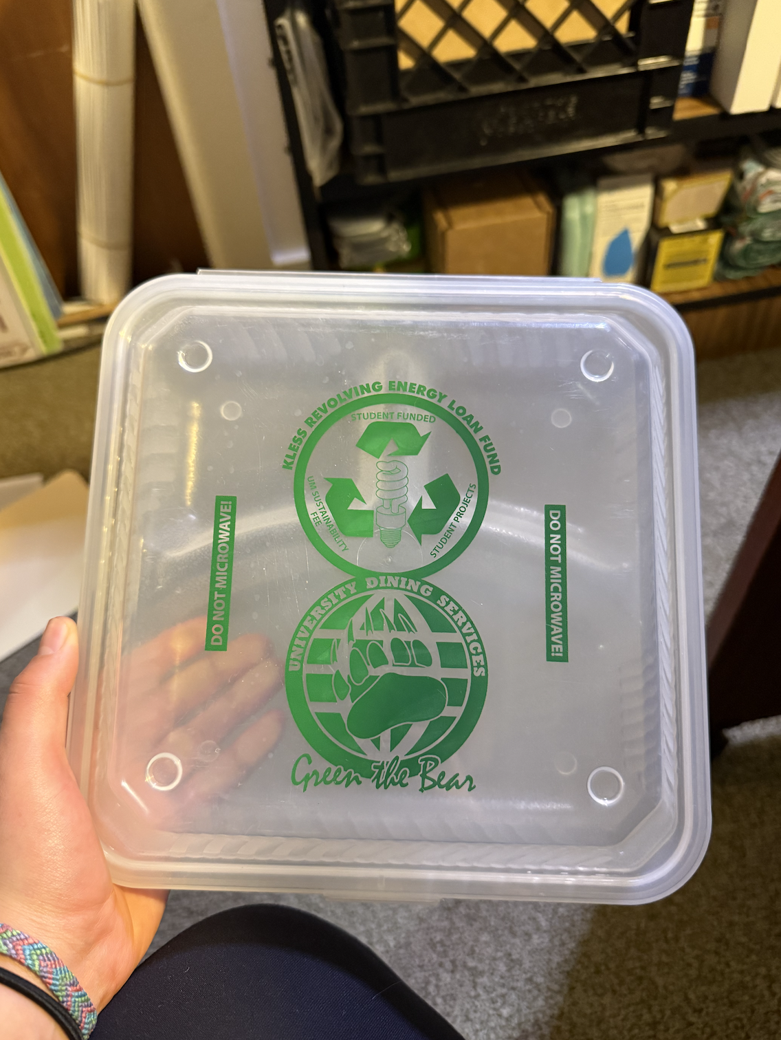 hand holding a reusable to go containers with KRELF logo
