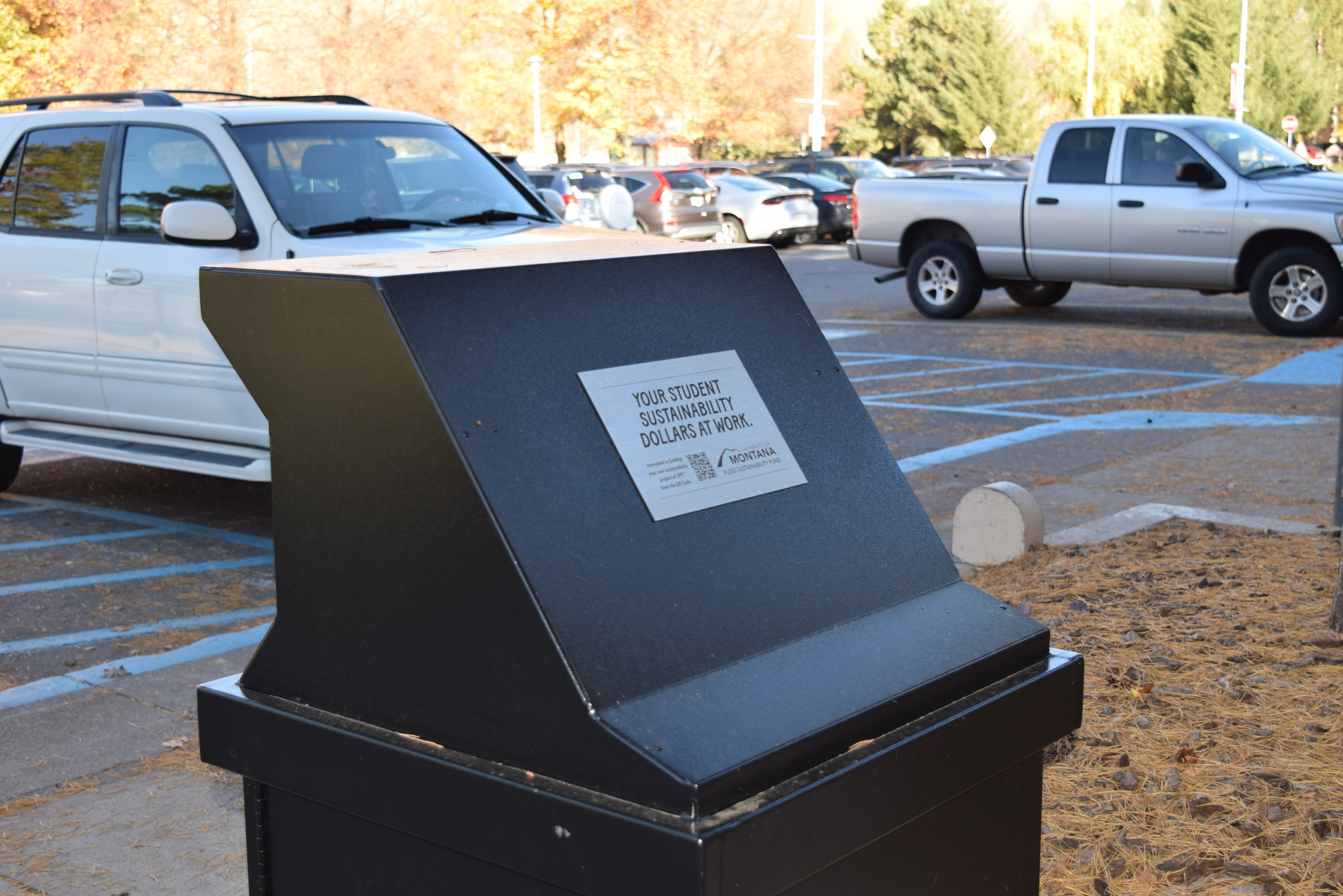 highlight of the bear safe garbage by the UC with cars in the back
