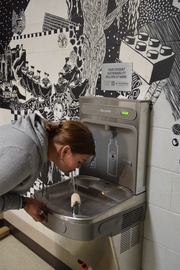 zoe drinking from new water bottle fill station in the art building