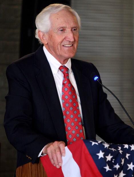 Larry Elison speaking at a podium.