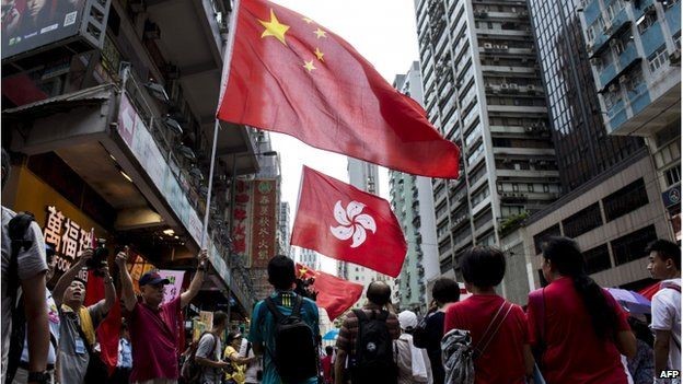 People hold the Chinese and Hong Kong flags as they take part in a pro-government rally in Hong Kong on August 17, 2014