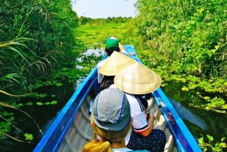 Students riding in a boat on a river in Vietnam