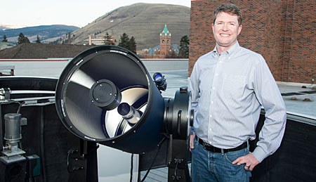 UM astrophysicist Nate McCrady poses with the University’s new 0.4-meter telescope atop the Skaggs Building.