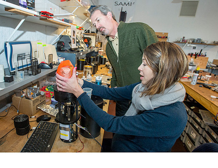 Janet Seidel, a Sunburst employee and UM alumna, puts a reagent bag on a SAMI-pH unit as Sunburst CEO Jim Beck looks on at the company headquarters in Missoula.