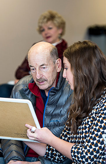 Jake Jacobsen, shown here working with UM graduate student Calley Bosch, participates in UM’s Big Sky Aphasia Program while his wife, Kristi, looks on.
