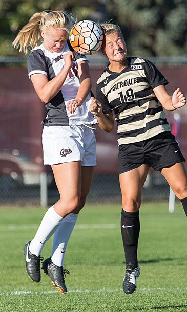 Hard knocks: UM soccer player Payton Agnew (left) goes for a header during a 2015 match against the Purdue Boilermakers. The student-athlete has volunteered to aid UM researchers who study concussions. (Photo by John Sieber)