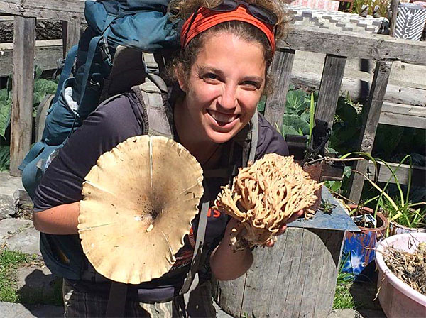 A picture of UM graduate Lily Clark holding mushrooms.