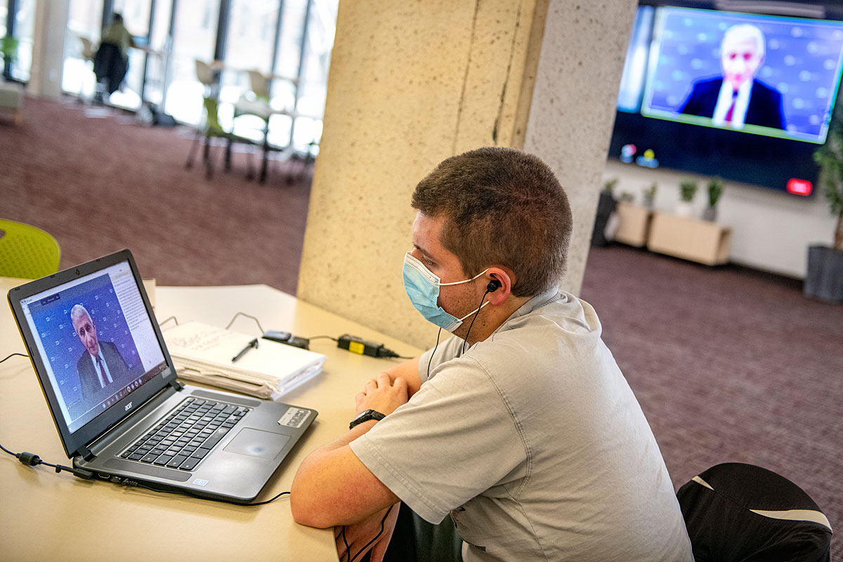 Student Nathaniel Miller watches Dr. Anthony Fauci speak to a UM audience.