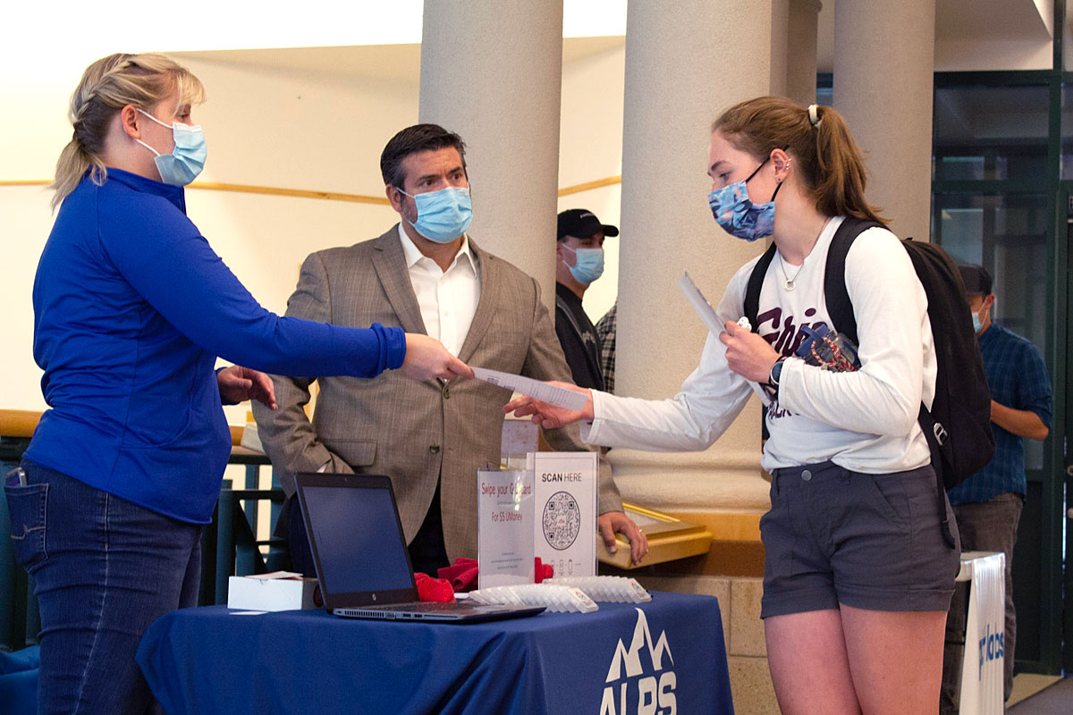 A UM business student chats with two potential employers. 