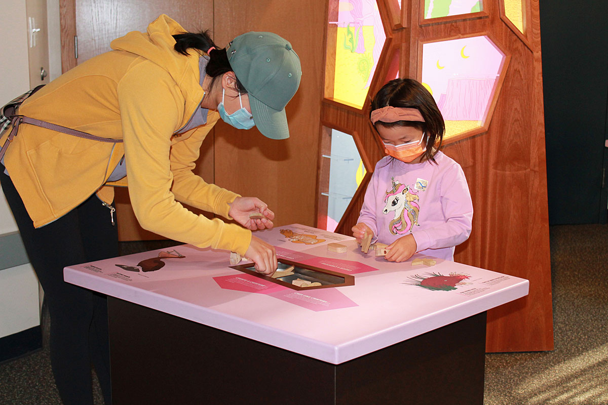 A mother and child explore hydrothermal vent communities as part of a “Life on the Edge” activity. 