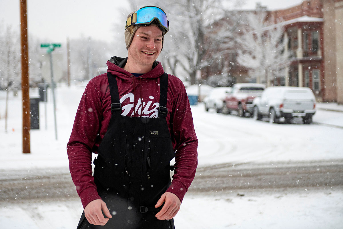 A UM student wearing ski goggles stands in the snow.