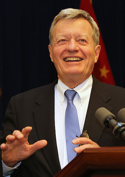 A picture of Max Baucus speaking at a podium.