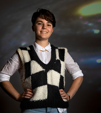 Ailey Robinson posing with hands on hips in the planetarium