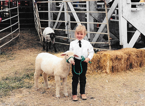 Photo of Erin Brush as a child with sheep