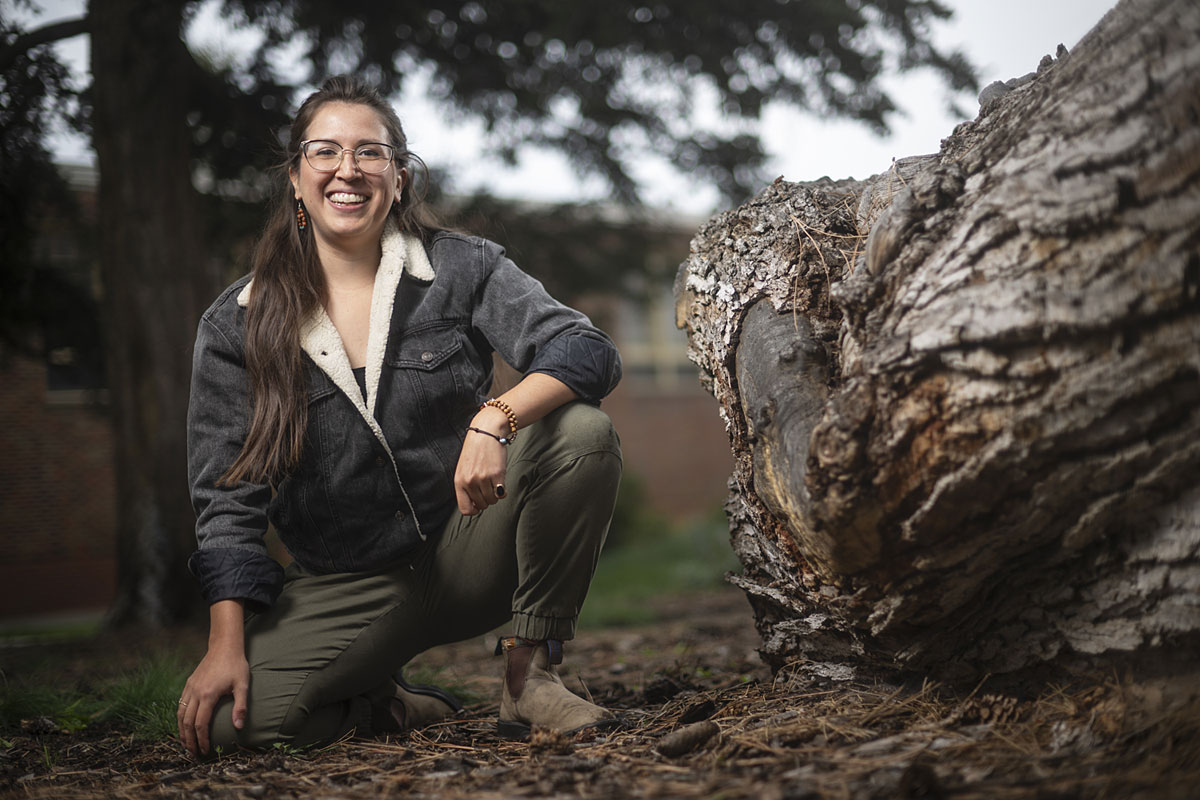 Stephanie Barron poses near a tree stump on campus.