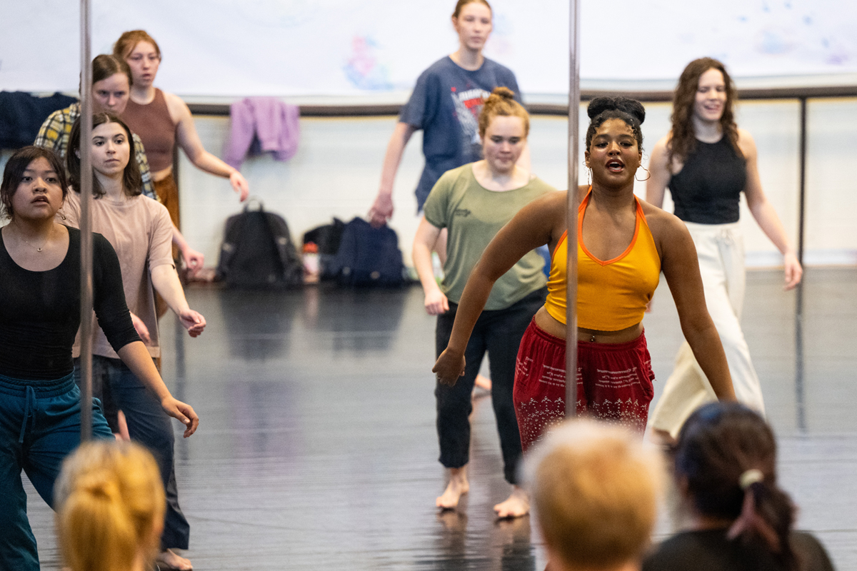 An image of students dancing in a studio in front of a mirror. 
