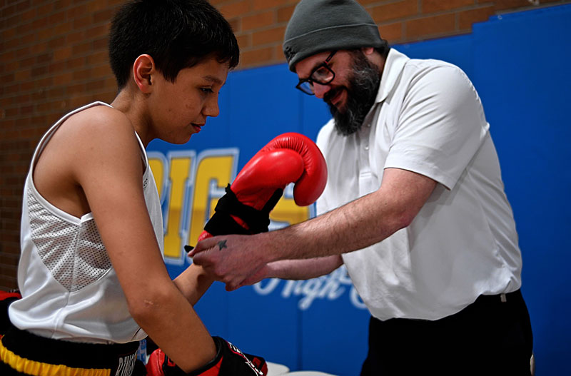 Dupuis Sr. helps his son, Ronald, with a boxing glove.