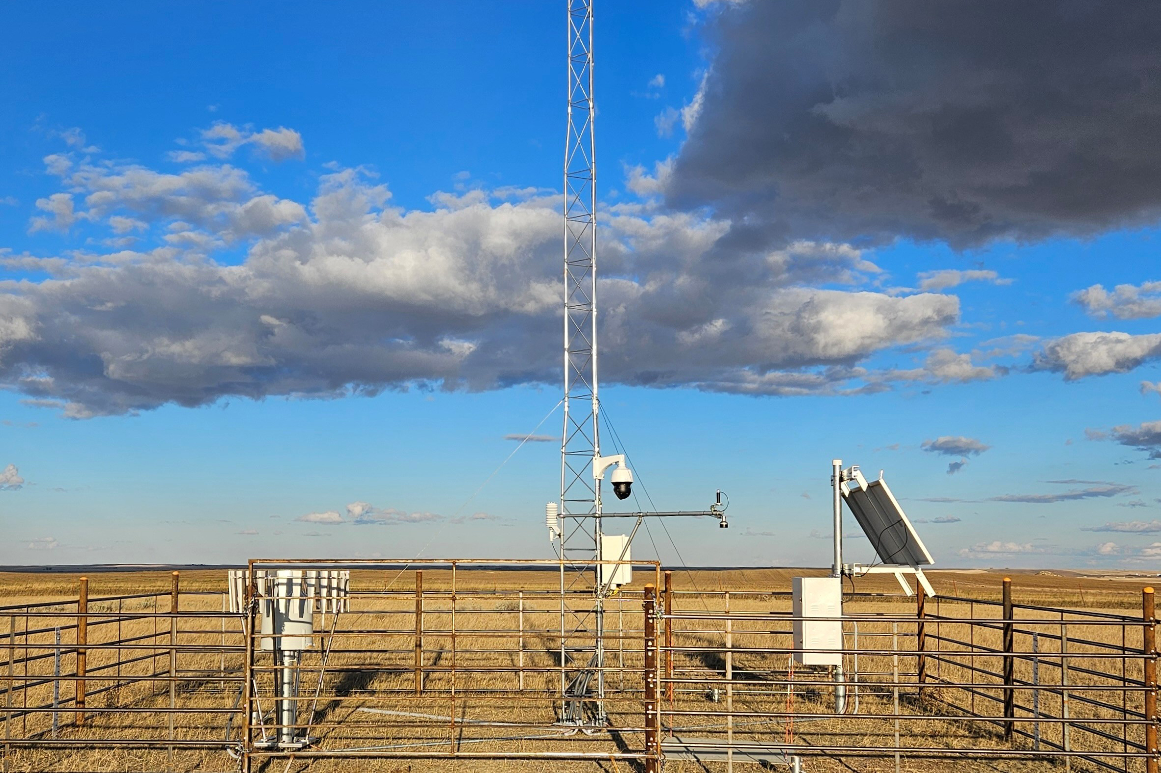 Station equipment sits on the prairie under a sky with lovely clouds.