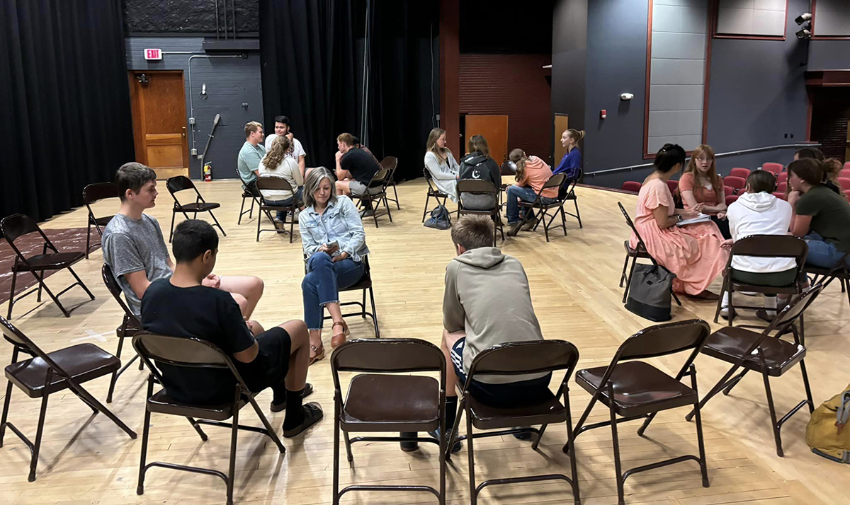 Conrad High School sitting in circular discussion groups.