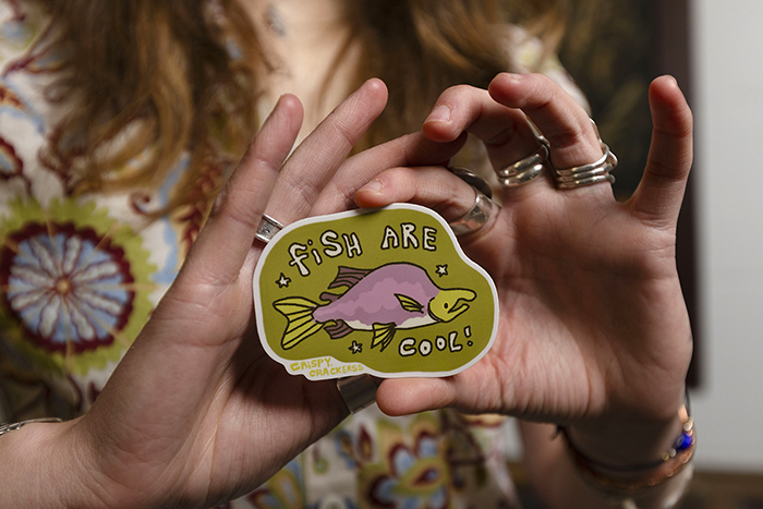 Kaltenecker holds a sticker that says "Fish Are Cool!"