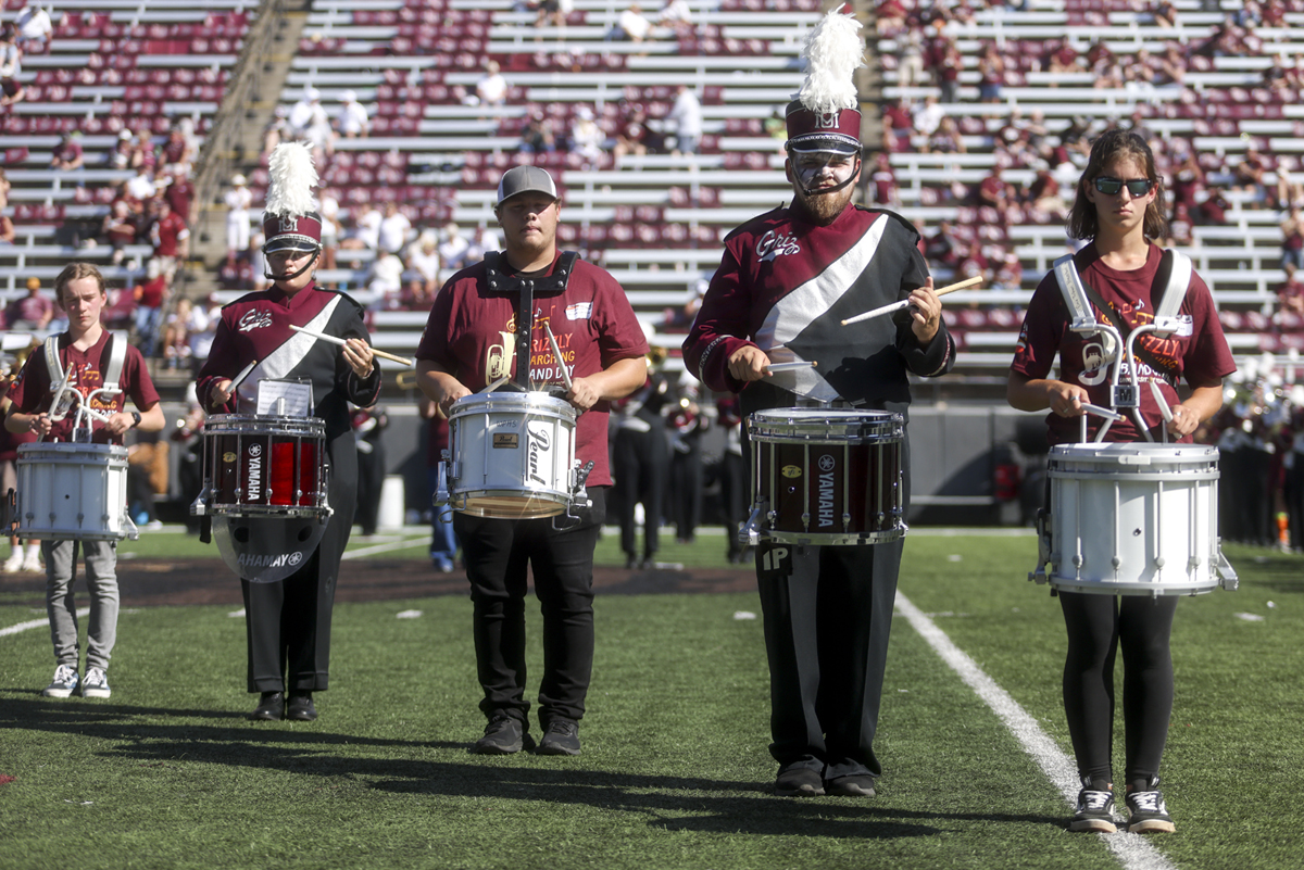 An image of high school and UM marching band members on the field. 
