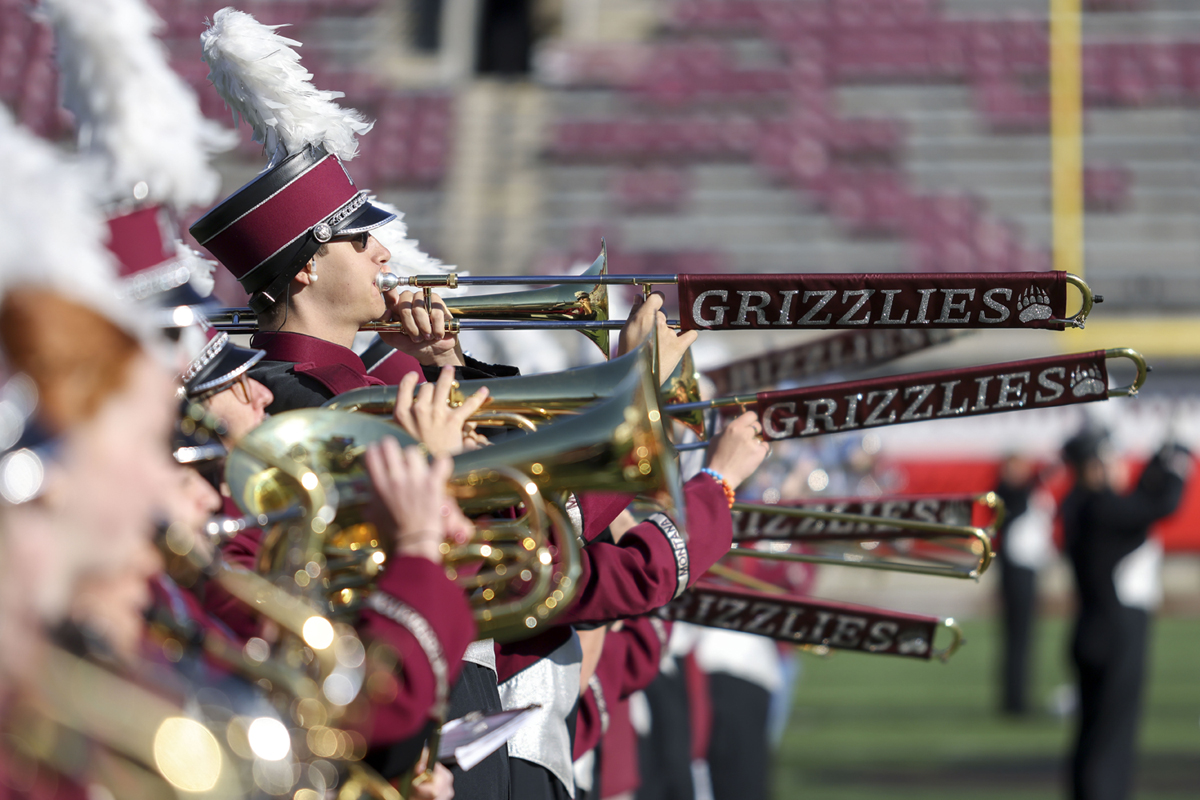 Grizzly Marching Band members and high school students on the field. 