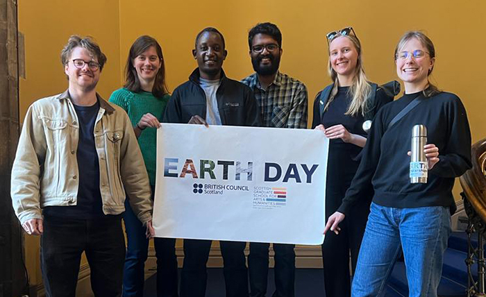 People line up with an EARTH Scholars banner. Denis is second from left.